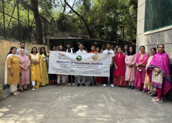 IVS faculty and students with the Institute of Vocational Studies banner